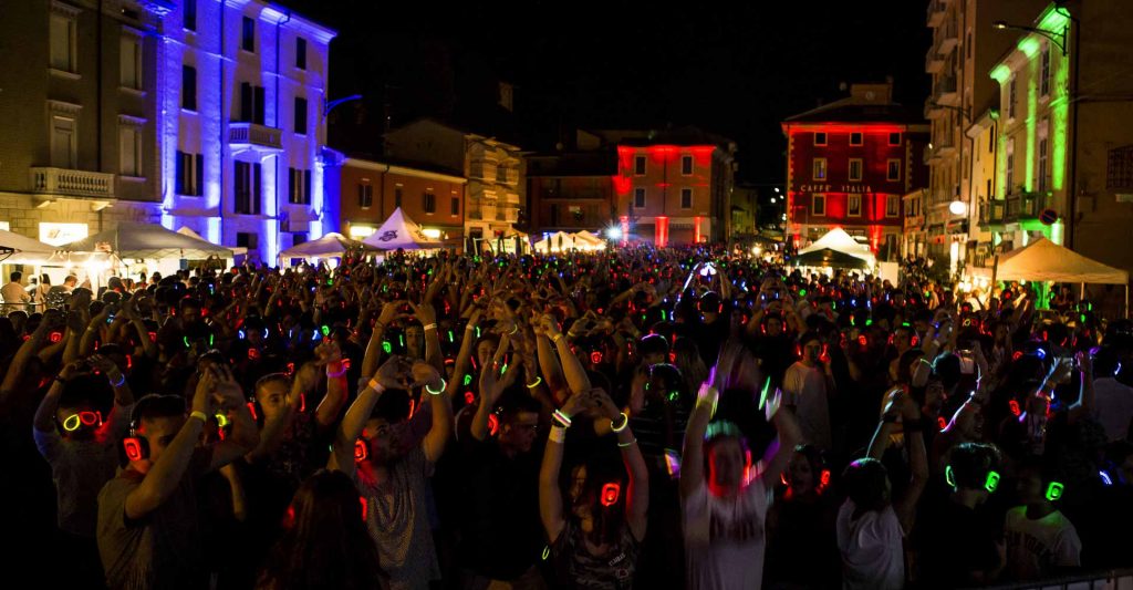 Platz bei Nacht mit Menschen mit Kopfhörern
